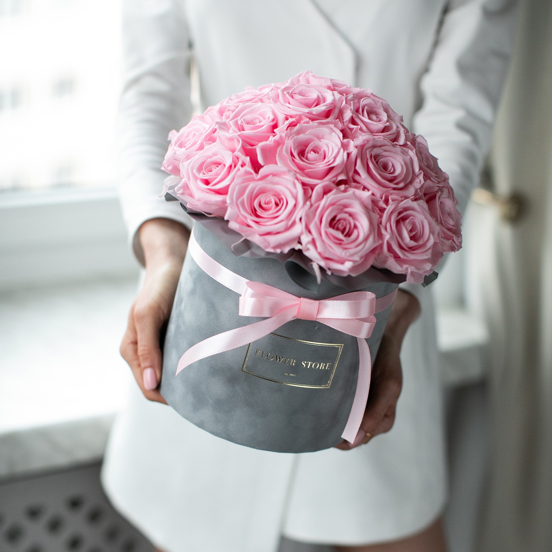 Eternal pink roses in a gray flocked box