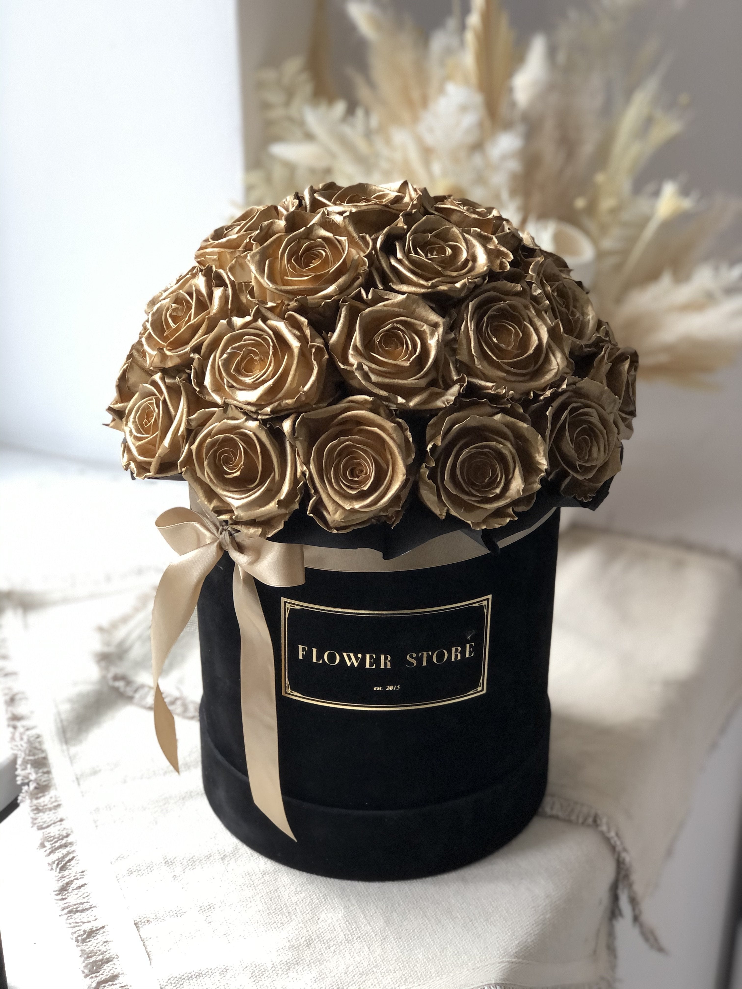 A large black box with golden eternal roses