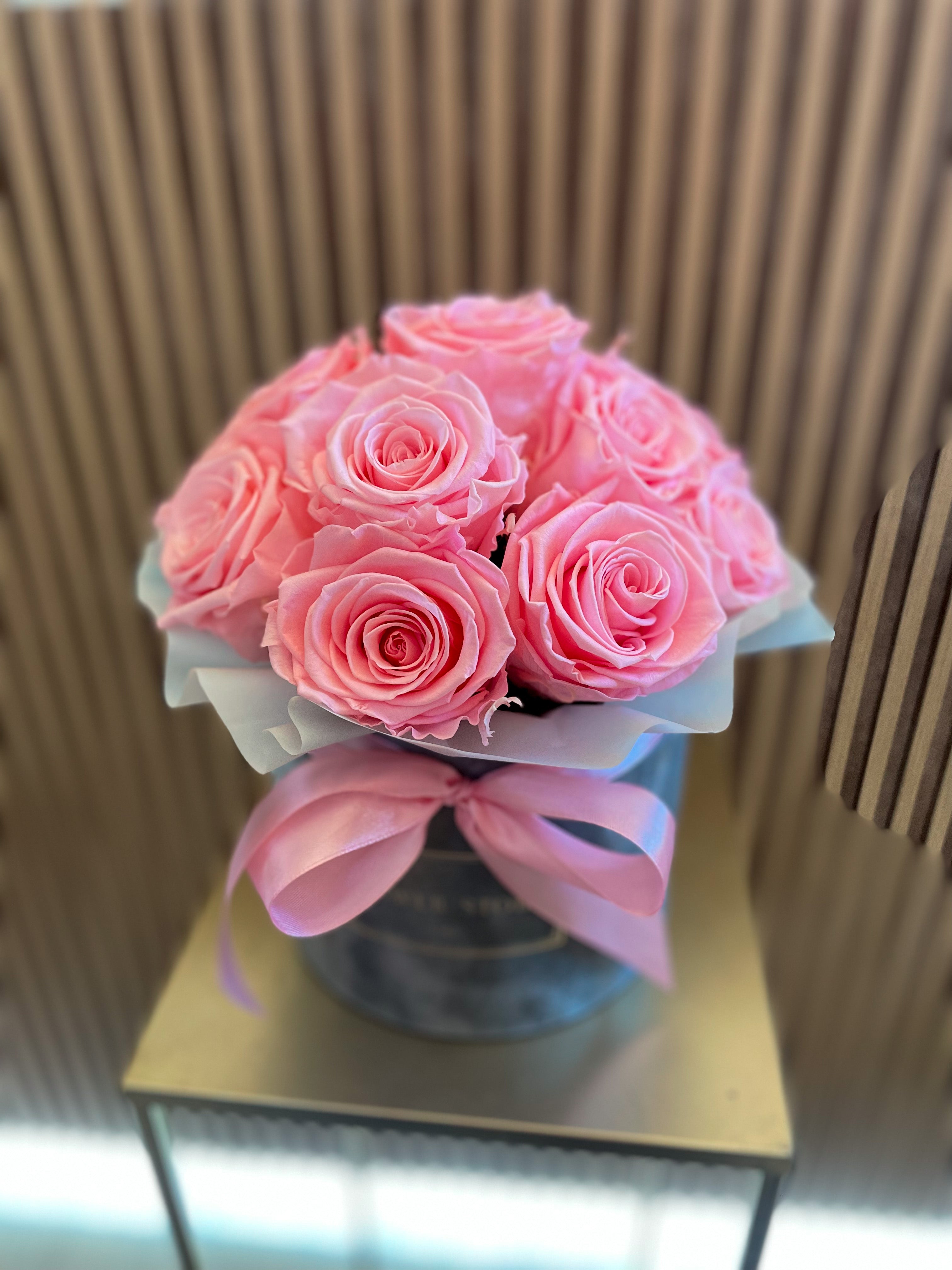 Eternal pink roses in a gray flocked box