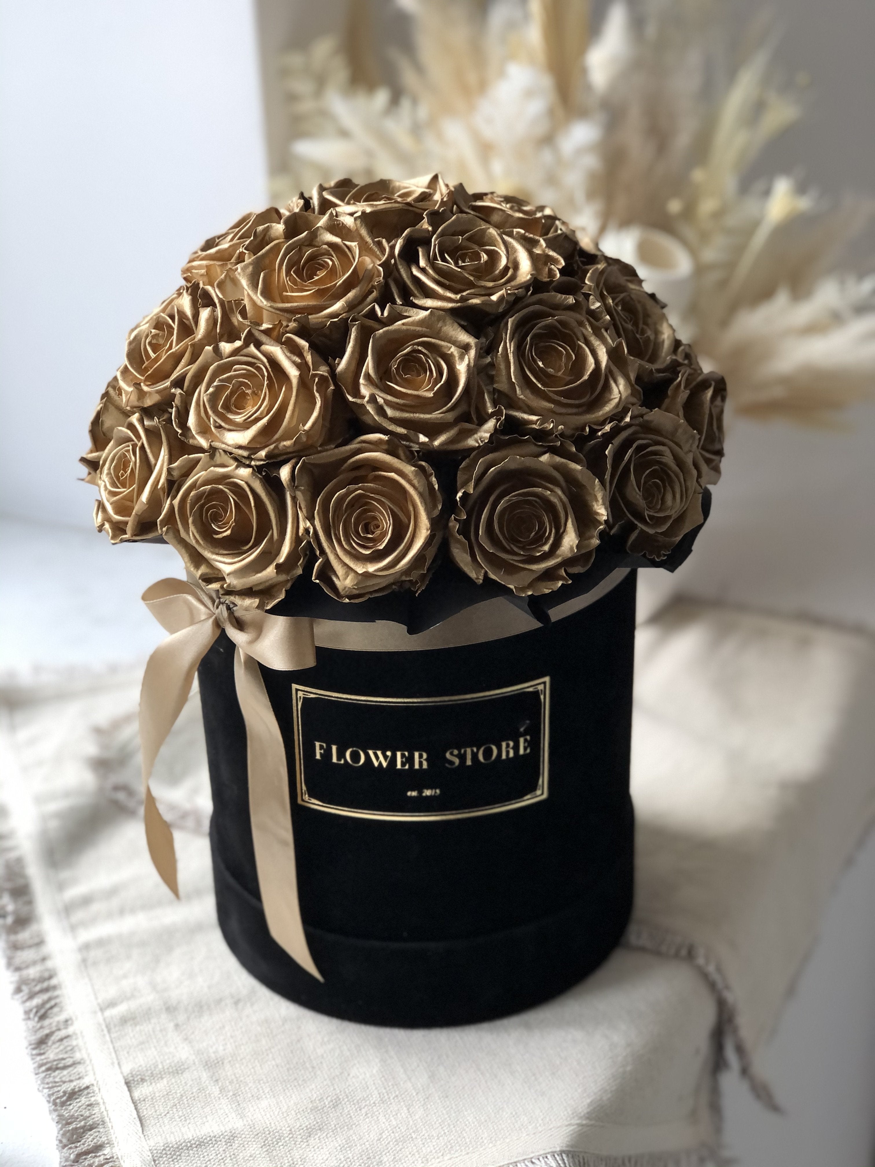 A large black box with golden eternal roses