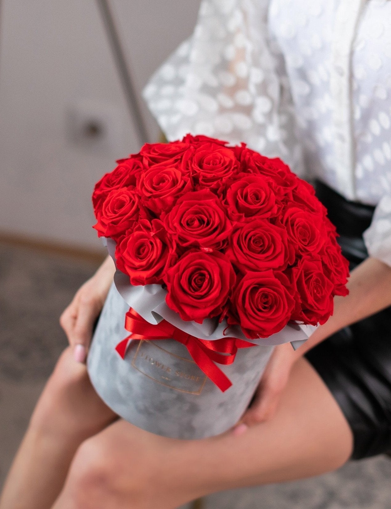 Eternal red roses in a gray flocked box