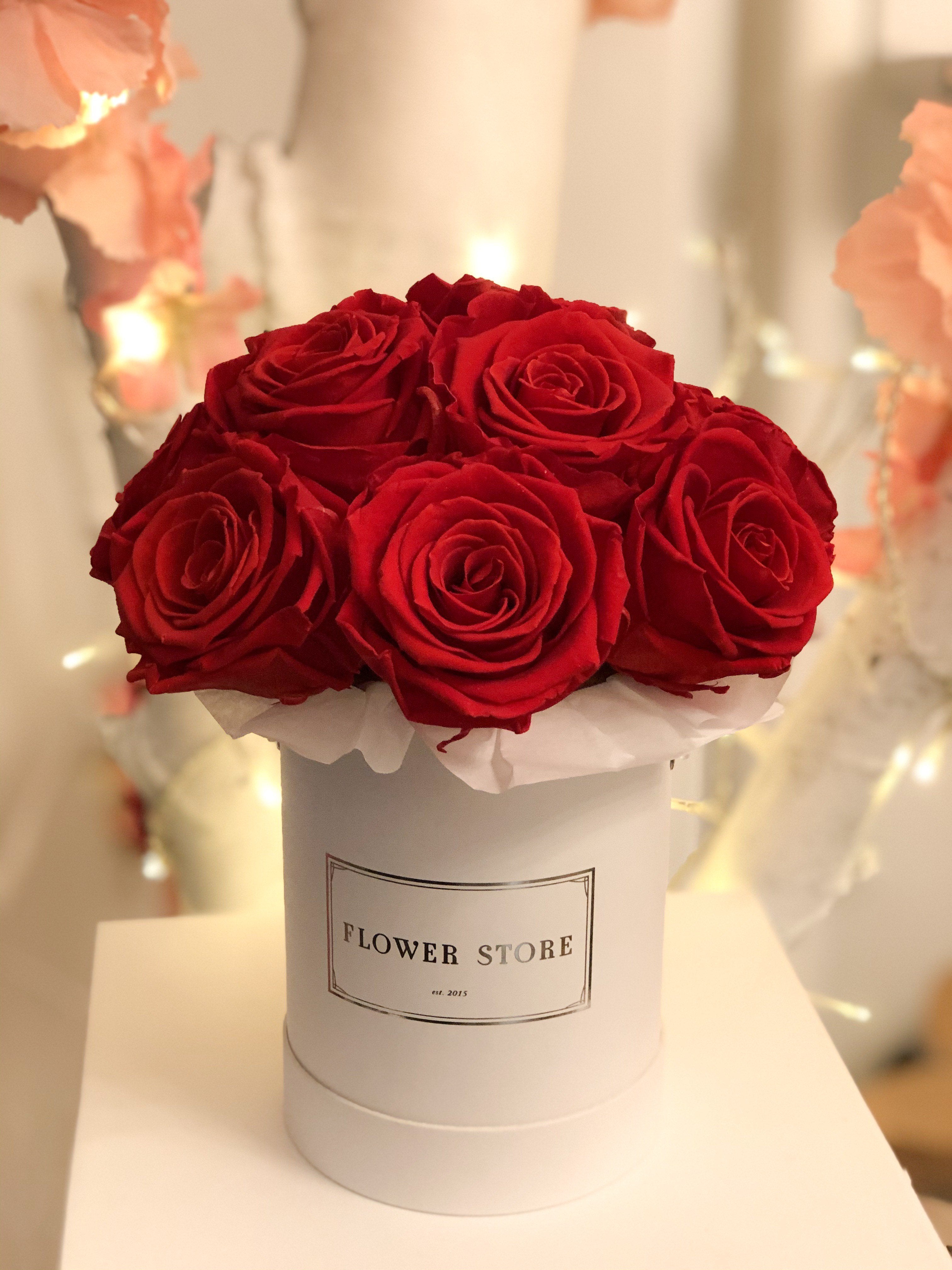 Маленькая белая коробочка с красными розами - живыми цветами.