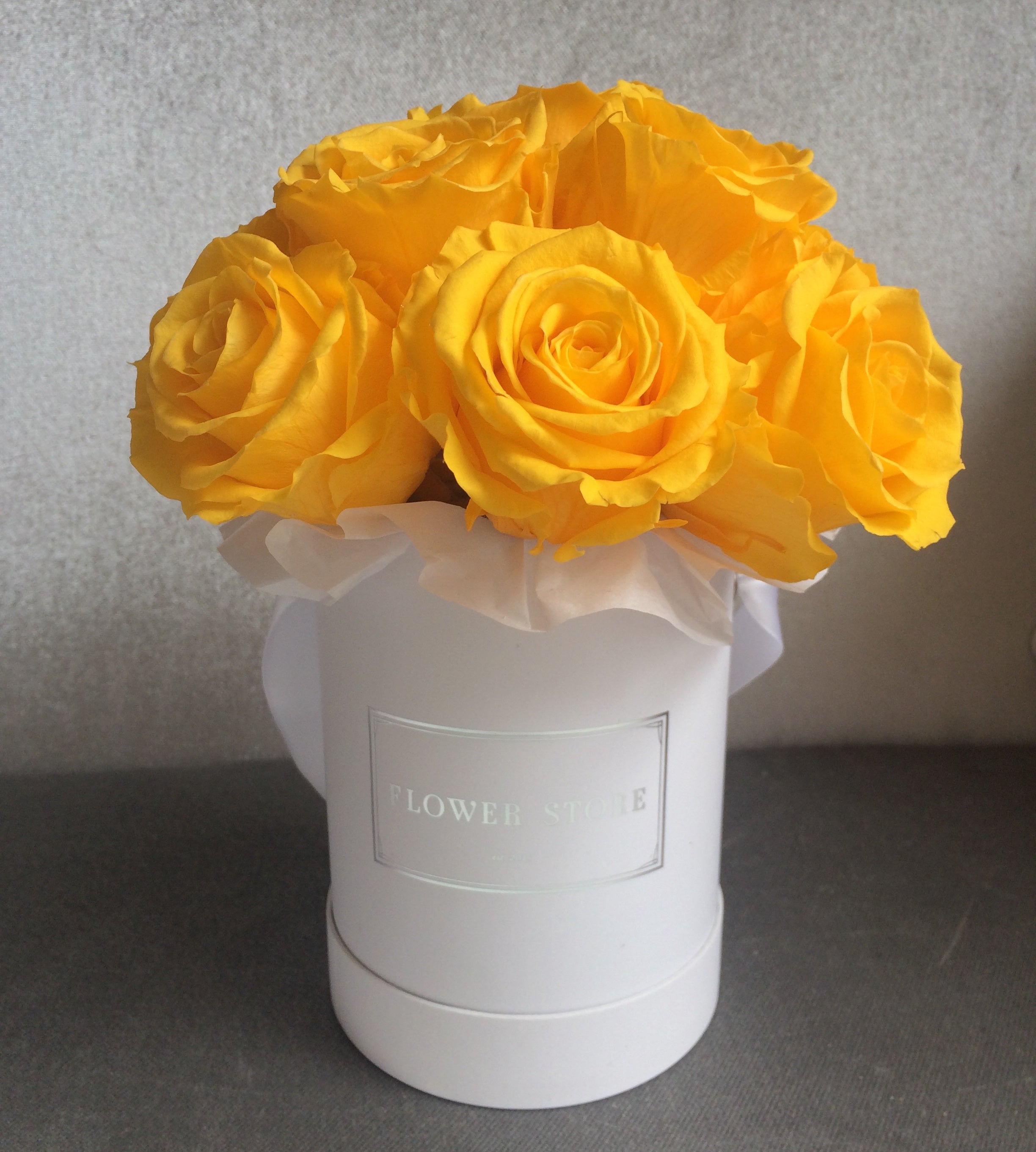 Yellow eternal roses in a white box