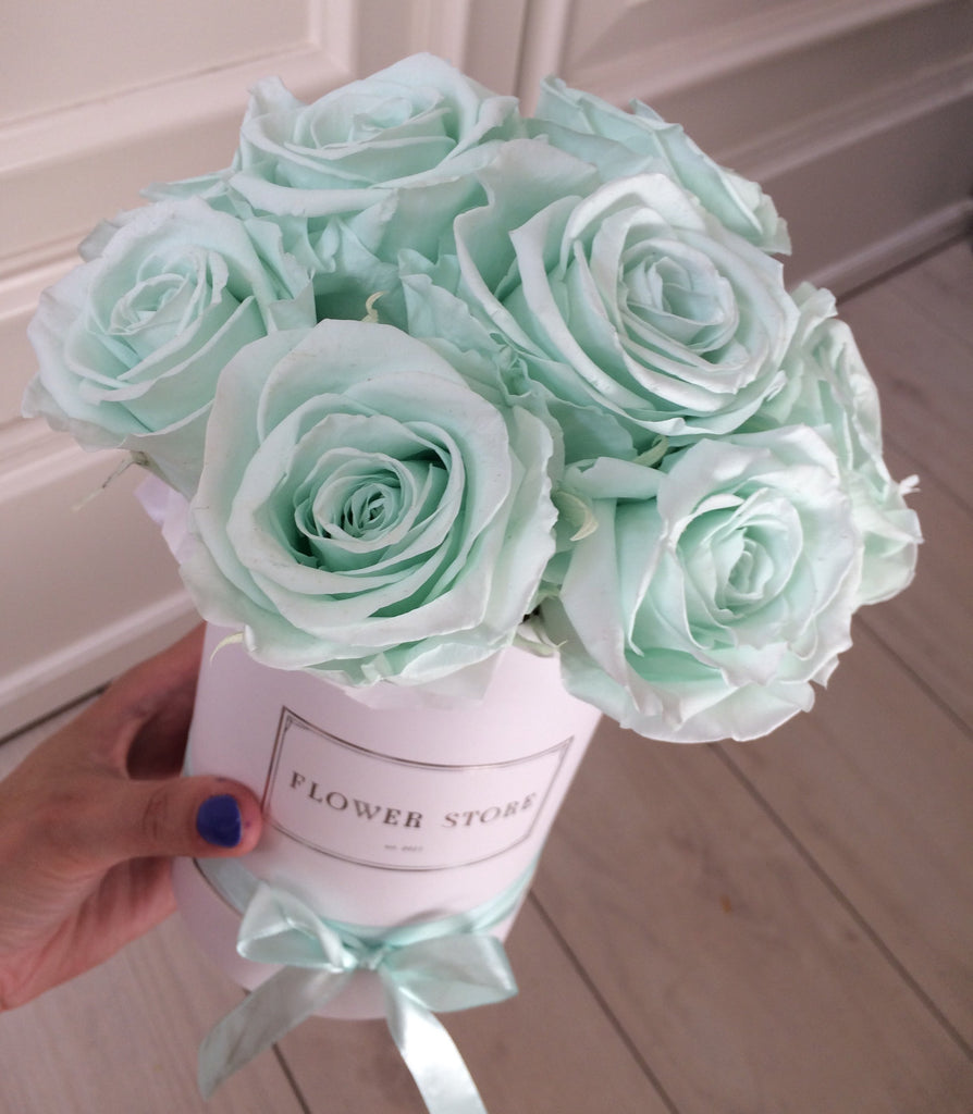 Małe białe pudełko z miętowymi wiecznymi różami