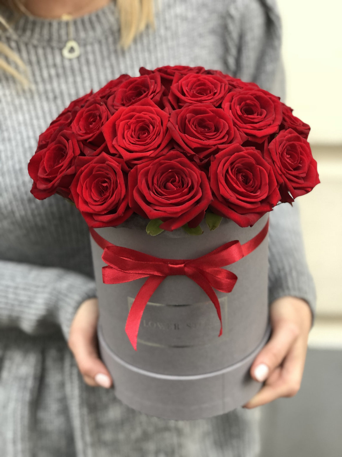 Średni szary flowerbox z czerwonymi żywymi różami