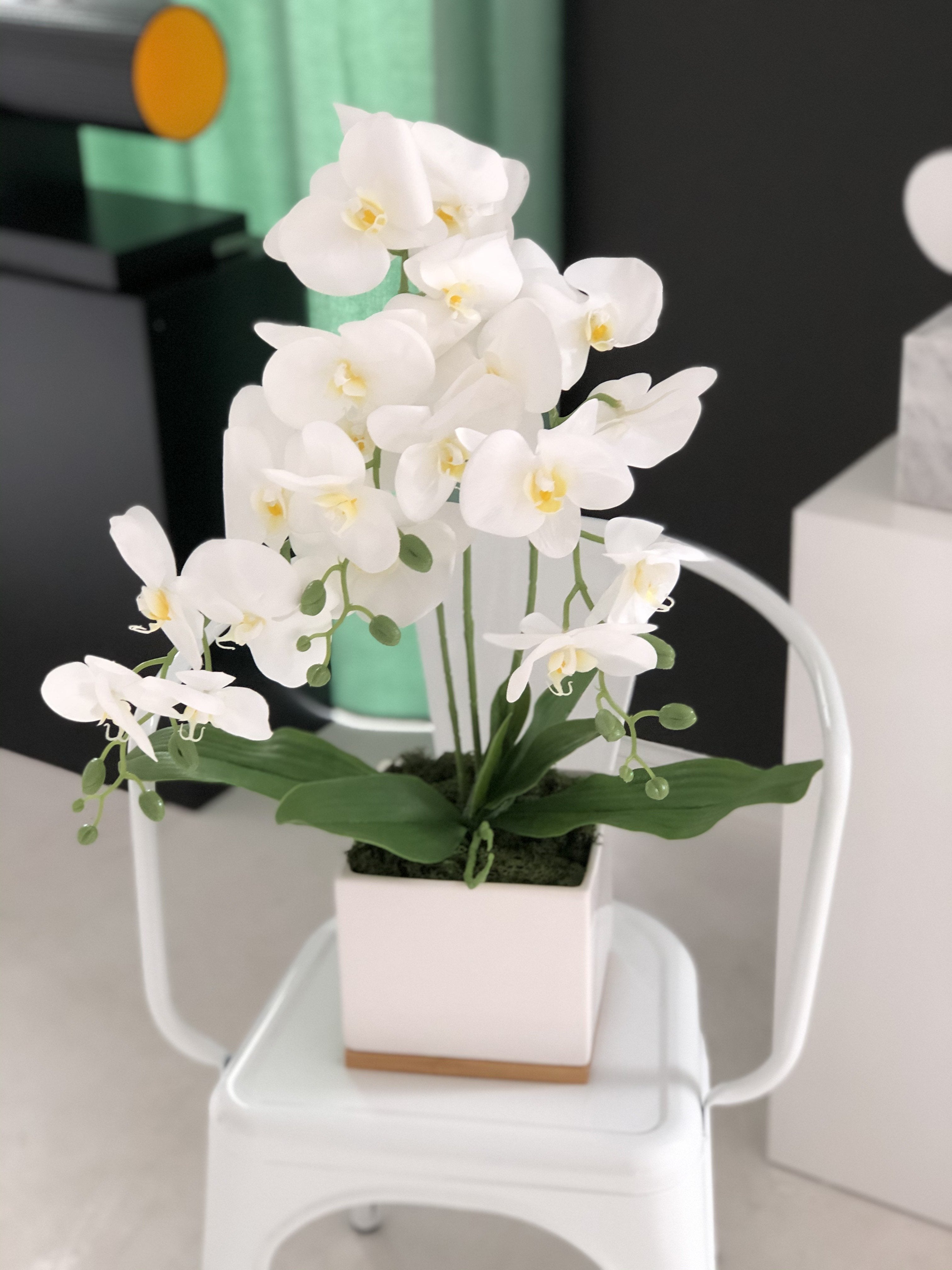 Эксклюзивная искусственная орхидея в белом горшке.
