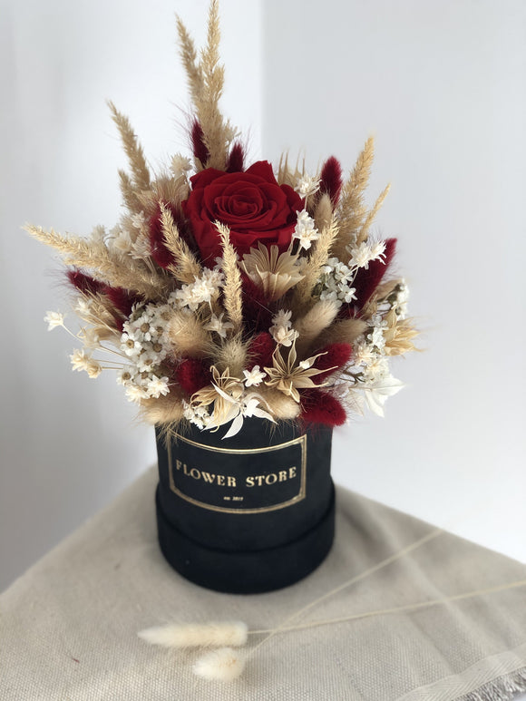 A small flocked dried flowerbox with a red eternal rose