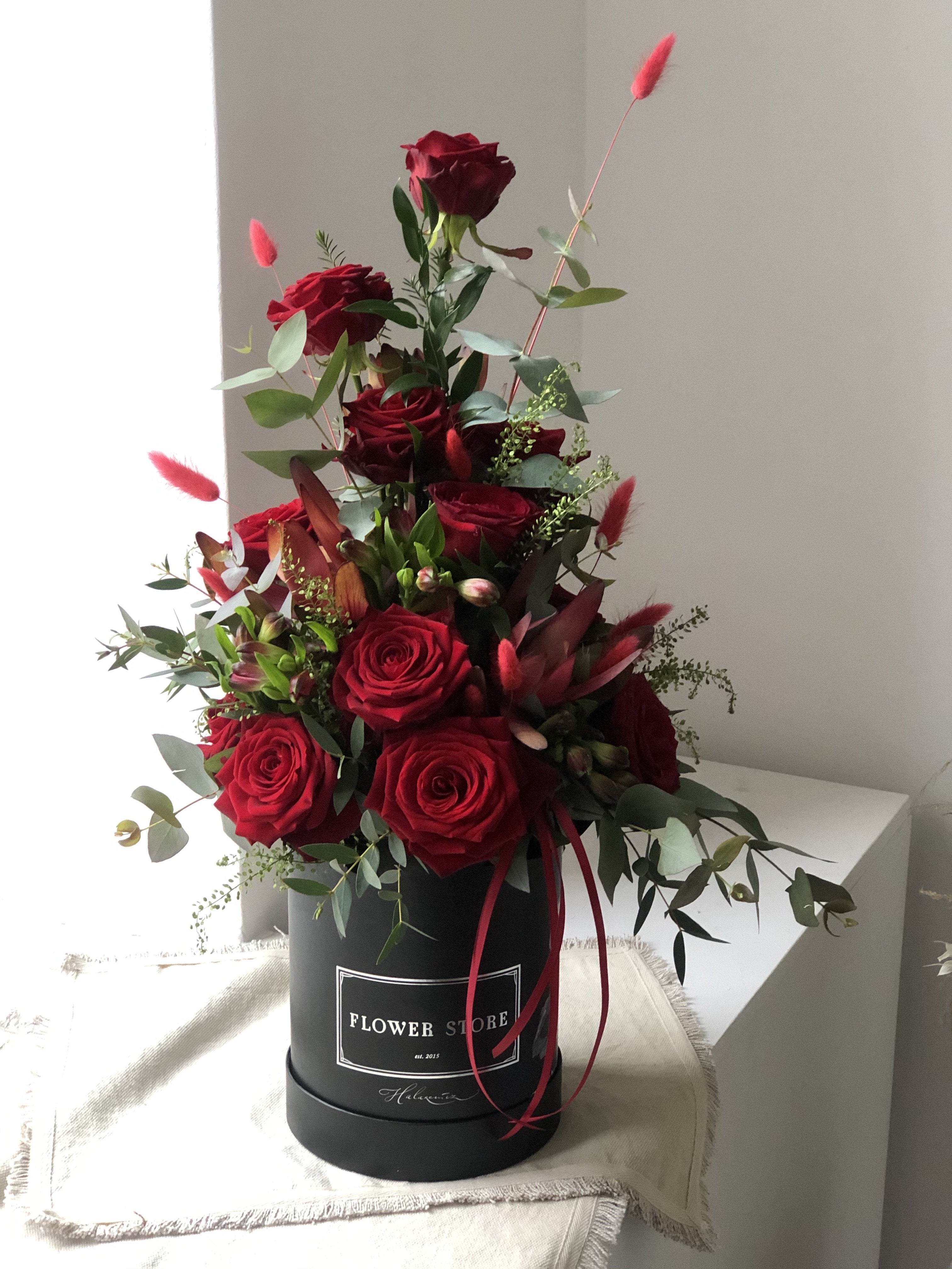 Composition with red roses - live flowers in a black box with graphics