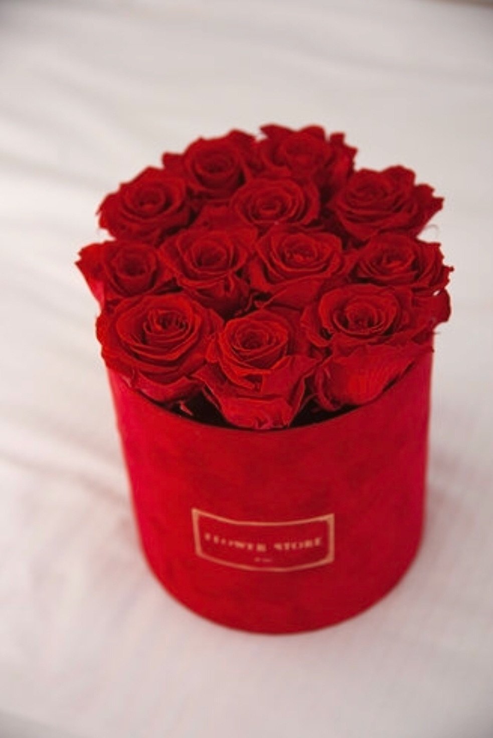 Красные розы в красной флокированной коробке - живые цветы.