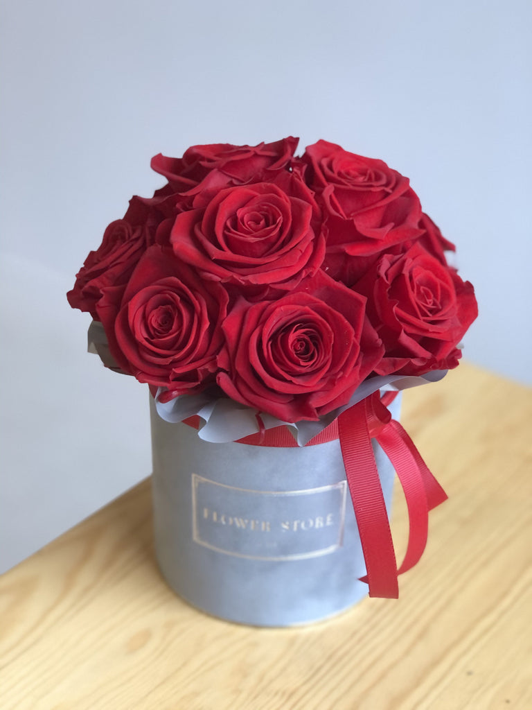 Mały szary flokowany flowerbox z czerwonymi wiecznymi różami