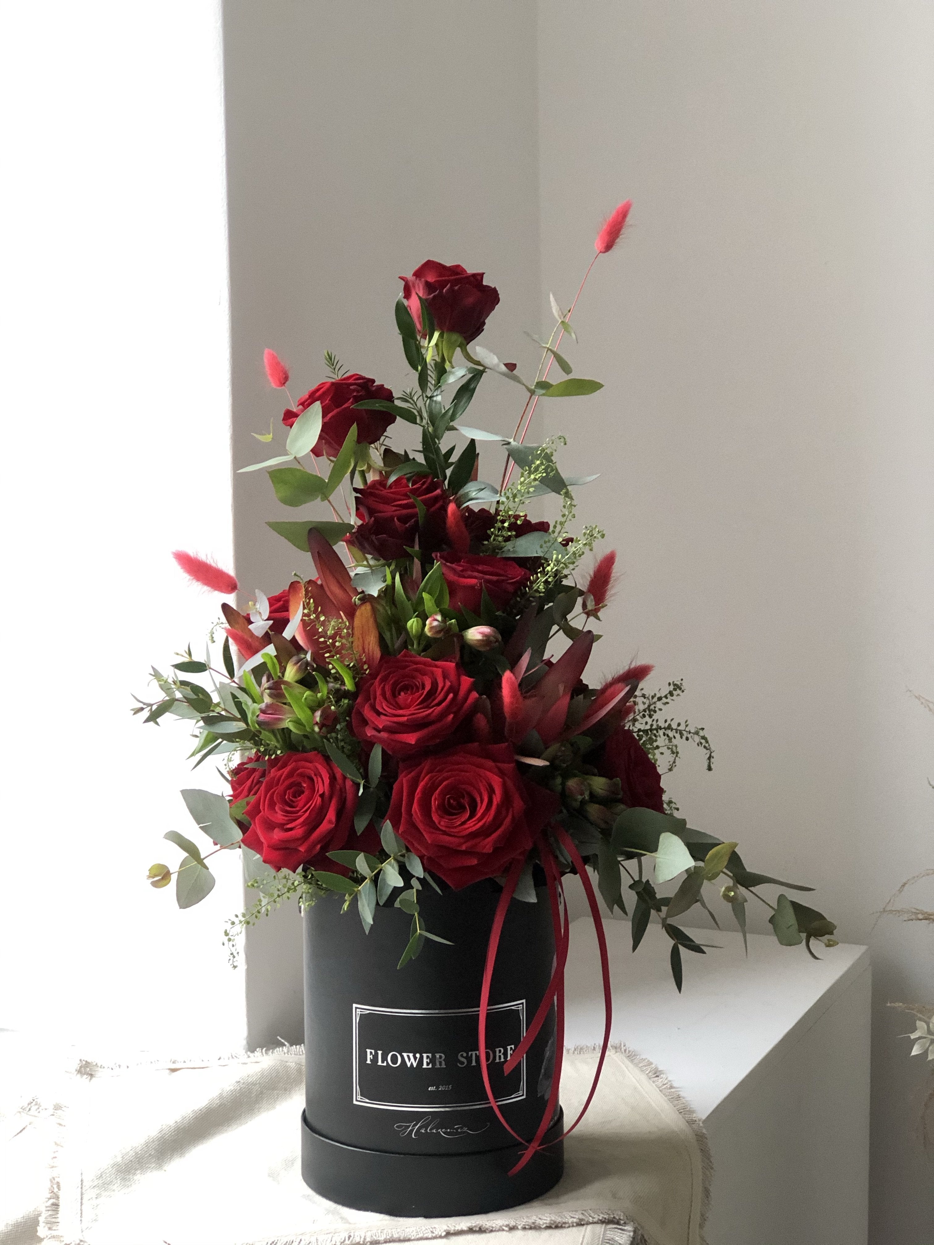Композиция из красных роз - живые цветы, черная коробка с графикой.