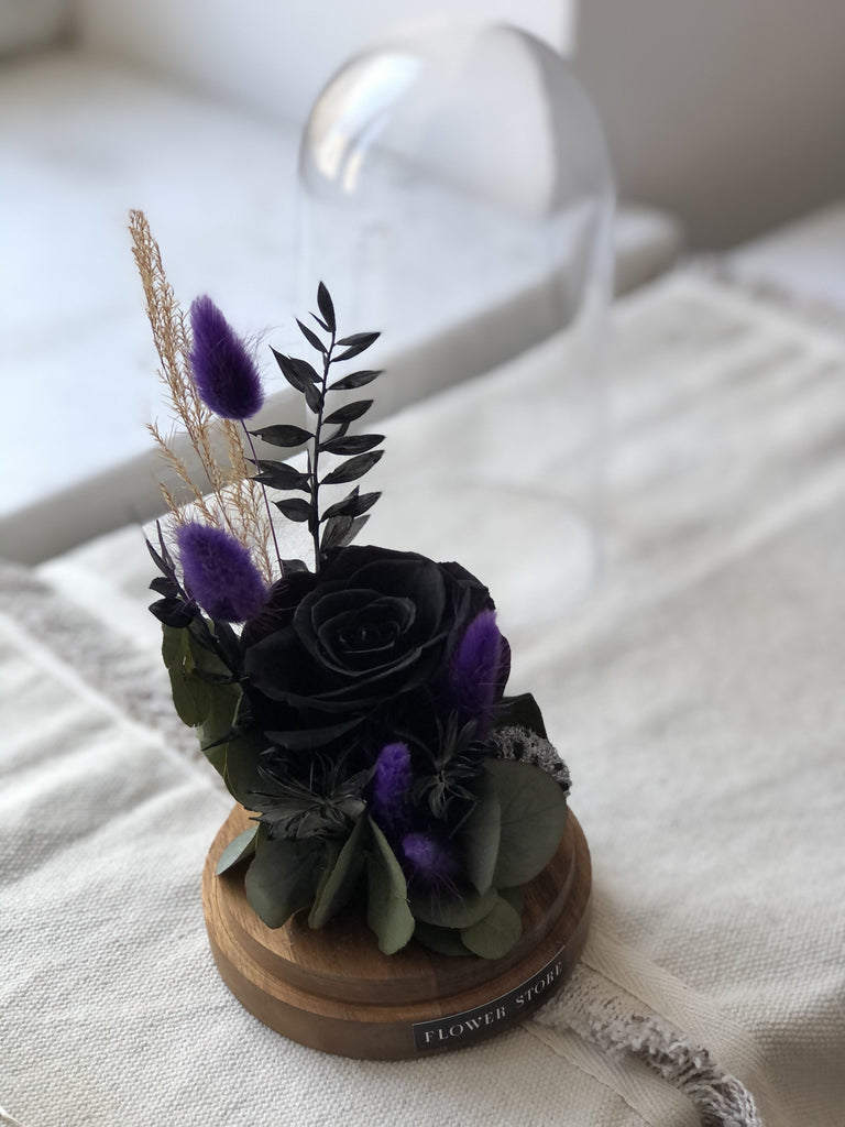 Dried composition with a black eternal rose in glass